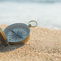 © respiro888 | stock.adobe.com | (compass on the golden sand by the sea)