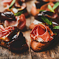 © Indstudio | freepik.com | (Crostini with prosciutto goat cheese and grilled figs on board)